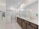 Bathroom featuring dual sinks, a large mirror, dark wood cabinets, and a glass-enclosed shower at 7206 Sw 60Th Ln, Ocala, FL 34474