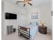 Well lit bedroom features a ceiling fan, TV, wardrobe and decor at 7206 Sw 60Th Ln, Ocala, FL 34474