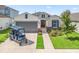 Well-manicured home exterior with stone accents, a grey garage door, and lush landscaping creates welcoming curb appeal at 7206 Sw 60Th Ln, Ocala, FL 34474