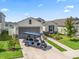 Charming single-Gathering home with a well-kept lawn, a grey garage door, and an inviting driveway with a golf cart at 7206 Sw 60Th Ln, Ocala, FL 34474