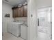 Convenient laundry room with tile flooring, washer, dryer, and cabinetry for storage, offering functionality and organization at 7206 Sw 60Th Ln, Ocala, FL 34474