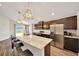 Kitchen with stainless appliances, dark cabinetry, island with seating, and backyard view at 8943 Se 41St Court Rd, Ocala, FL 34480