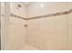 Tiled shower featuring built-in niche and a decorative mosaic tile accent strip at 8943 Se 41St Court Rd, Ocala, FL 34480