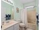 Well-lit bathroom with light green walls, neutral tile, and walk-in shower/tub at 9408 Se 132Nd Loop, Summerfield, FL 34491