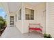 Inviting front porch with covered entry, charming bench, and well-maintained landscaping at 9408 Se 132Nd Loop, Summerfield, FL 34491