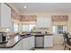 Well-lit kitchen sink area with stainless steel dishwasher, decorative accents, and backyard views at 9408 Se 132Nd Loop, Summerfield, FL 34491