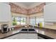 Kitchen sink area with decorative accents and a view to the backyard through a bright sunny window at 9408 Se 132Nd Loop, Summerfield, FL 34491