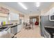 Eat-in kitchen featuring stainless steel appliances, tile floors, eat-in table, and views into the living room at 9408 Se 132Nd Loop, Summerfield, FL 34491