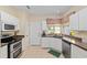 Well-lit kitchen featuring stainless steel appliances and tile floors, creating a modern cooking space at 9408 Se 132Nd Loop, Summerfield, FL 34491
