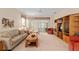 Spacious living room with neutral carpet, ceiling fan, and comfortable furnishings at 9408 Se 132Nd Loop, Summerfield, FL 34491