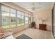 Bright sunroom with tile flooring, ceiling fan, and large windows for natural light and views of the outdoors at 9408 Se 132Nd Loop, Summerfield, FL 34491