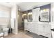 Bathroom boasts double sinks with white cabinets, large mirrors, and glass enclosed shower at 9750 Sw 97Th Pl, Ocala, FL 34481