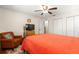 Bedroom featuring wood floors, ceiling fan, twin closets, and warm orange bedspread at 9750 Sw 97Th Pl, Ocala, FL 34481