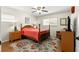 Cozy bedroom with a wooden bed frame, colorful rug, and comfortable seating area at 9750 Sw 97Th Pl, Ocala, FL 34481