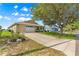 Well-maintained single-story home featuring a long driveway and a green lawn at 9750 Sw 97Th Pl, Ocala, FL 34481
