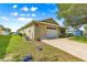 Single-story home featuring an attached garage and green lawn at 9750 Sw 97Th Pl, Ocala, FL 34481