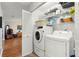 Convenient laundry room with shelving above washer and dryer; open to living area at 9750 Sw 97Th Pl, Ocala, FL 34481