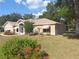 The exterior showcases a well-maintained lawn, mature trees, and meticulously landscaped flower beds around the residence at 1001 Ne 22Nd Ave, Ocala, FL 34470