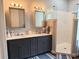 Bathroom vanity with dual sinks, framed mirrors, and a walk-in shower at 10208 Se 170 Pl, Summerfield, FL 34491