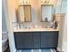 Bathroom vanity with dual sinks, framed mirrors, grey cabinetry, and walk-in shower at 10208 Se 170 Pl, Summerfield, FL 34491