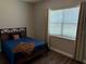 Cozy bedroom with neutral walls, wood laminate flooring, and lots of natural light at 10208 Se 170 Pl, Summerfield, FL 34491