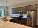 Bright kitchen features stainless steel appliances, gray cabinets, and lovely backsplash at 10208 Se 170 Pl, Summerfield, FL 34491