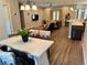 Open-concept living area featuring stylish furnishings and wood laminate flooring at 10208 Se 170 Pl, Summerfield, FL 34491
