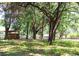 A sunny view of the large property, with horse stall, lush lawns, trees and fencing at 10208 Se 170 Pl, Summerfield, FL 34491