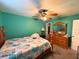 This bedroom is painted blue and has a wooden bed frame and ceiling fan at 14 Dogwood Drive Radl, Ocala, FL 34472