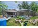 Expansive backyard featuring a screened pool, fire pit, swing, and outdoor kitchen at 14330 Sw 79Th Ter, Ocala, FL 34473