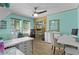 Light-filled home office with aqua walls, hardwood floors, open shelving, and modern computer at 14330 Sw 79Th Ter, Ocala, FL 34473