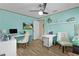 Bright home office with aqua walls, ceiling fan, modern computer setup, and hardwood floors at 14330 Sw 79Th Ter, Ocala, FL 34473