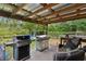 Relaxing outdoor kitchen with covered patio, grill, and lush green surroundings at 14330 Sw 79Th Ter, Ocala, FL 34473