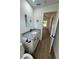 A view of a bathroom with granite vanity, black fixtures, and wood-look floors at 14415 Sw 21St Pl, Ocala, FL 34481