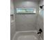 A view of the bathtub, shower, and window in a tiled bathroom at 14415 Sw 21St Pl, Ocala, FL 34481