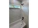 This shower-tub combo features marble-look wall tiles, a black shower head and window at 14415 Sw 21St Pl, Ocala, FL 34481