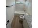 Bright bathroom featuring wood-look flooring, shower-tub combo, granite vanity and black fixtures at 14415 Sw 21St Pl, Ocala, FL 34481