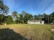 A new home on a spacious lot with trees in the background beneath a blue sky with light clouds at 14415 Sw 21St Pl, Ocala, FL 34481