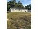 A view of the home's backyard and exterior featuring the lawn, siding and windows at 14425 Sw 21St Pl, Ocala, FL 34481