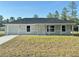 Lovely one-story home featuring a neutral color scheme, attached garage, and a lush green front yard at 14425 Sw 21St Pl, Ocala, FL 34481