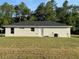Back of a single story home with gray roof, central door and green grass at 14425 Sw 21St Pl, Ocala, FL 34481