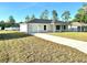 Well-maintained single-story home with attached garage, long driveway, and green front lawn at 14425 Sw 21St Pl, Ocala, FL 34481