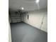 A spacious garage showcasing painted floors, lighting, and an automatic door at 14425 Sw 21St Pl, Ocala, FL 34481
