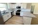 Modern kitchen featuring white cabinets, granite counters, stainless appliances, and hard wood flooring at 14425 Sw 21St Pl, Ocala, FL 34481