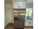 Stainless steel refrigerator compliments the white cabinets, countertops and view to the backyard at 14425 Sw 21St Pl, Ocala, FL 34481