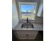 Kitchen sink with stainless steel hardware and white cabinets below, with a view of the backyard at 14425 Sw 21St Pl, Ocala, FL 34481