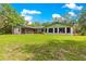Expansive backyard featuring a well-maintained lawn and a screened in porch at 17150 Se 168Th Ter, Weirsdale, FL 32195