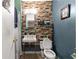 Bathroom features unique brick accent wall, sink with exposed pipes, and a tiled shower area at 17150 Se 168Th Ter, Weirsdale, FL 32195
