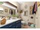 Bathroom featuring blue vanity with laminate countertops and decorative artwork at 17150 Se 168Th Ter, Weirsdale, FL 32195