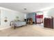 Bright bedroom featuring a bed, desk area, and a glimpse into a bedroom with red drapes at 17150 Se 168Th Ter, Weirsdale, FL 32195